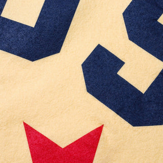 Detail of navy USA lettering and red star screen-printed on cream wool felt
