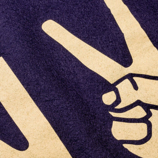 Close-up of the cream peace-sign hand detail screen-printed on navy wool felt