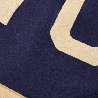Close-up of cream NYC lettering screen-printed on navy wool felt