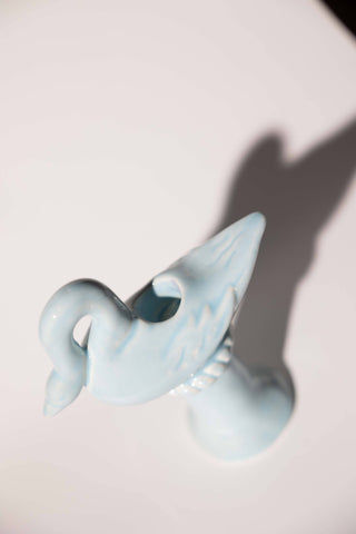 Overhead view of the light blue ceramic swan candlestick holder showing the round taper socket set into the swan's back and the carved wing feathers