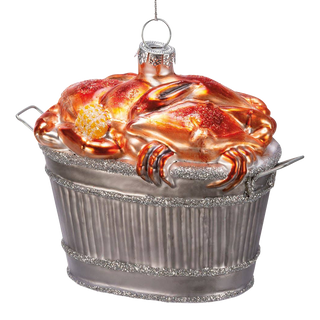 Glass crab bushel ornament — a heap of red-orange glass crabs with an ear of corn piled in a glittered silver bushel basket, silver cap and hanging loop on top, on a white background
