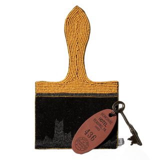 Paint brush pouch shown with a vintage brass hotel key for scale, gold seed-beaded handle and velvet body