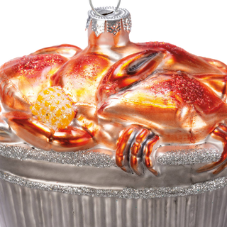 Close-up of the ornament's top — painted glass crabs and corn cob detail with glitter along the bushel rim